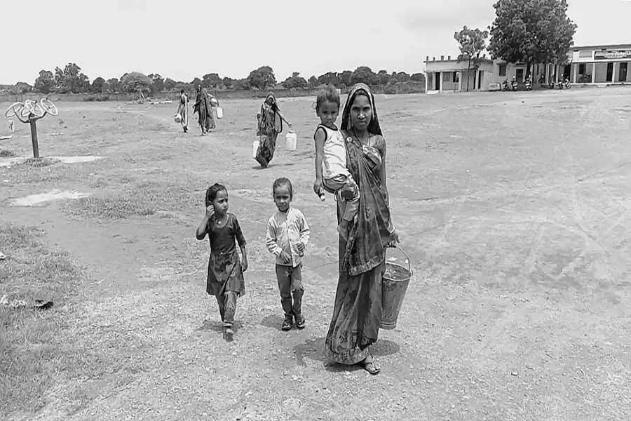 Pregnant Parvati Parmar walks back after fetching a bucket of water from the handpump near her house in Mongrol, Ratlam, Rajasthan (Photo - SR Pareek)